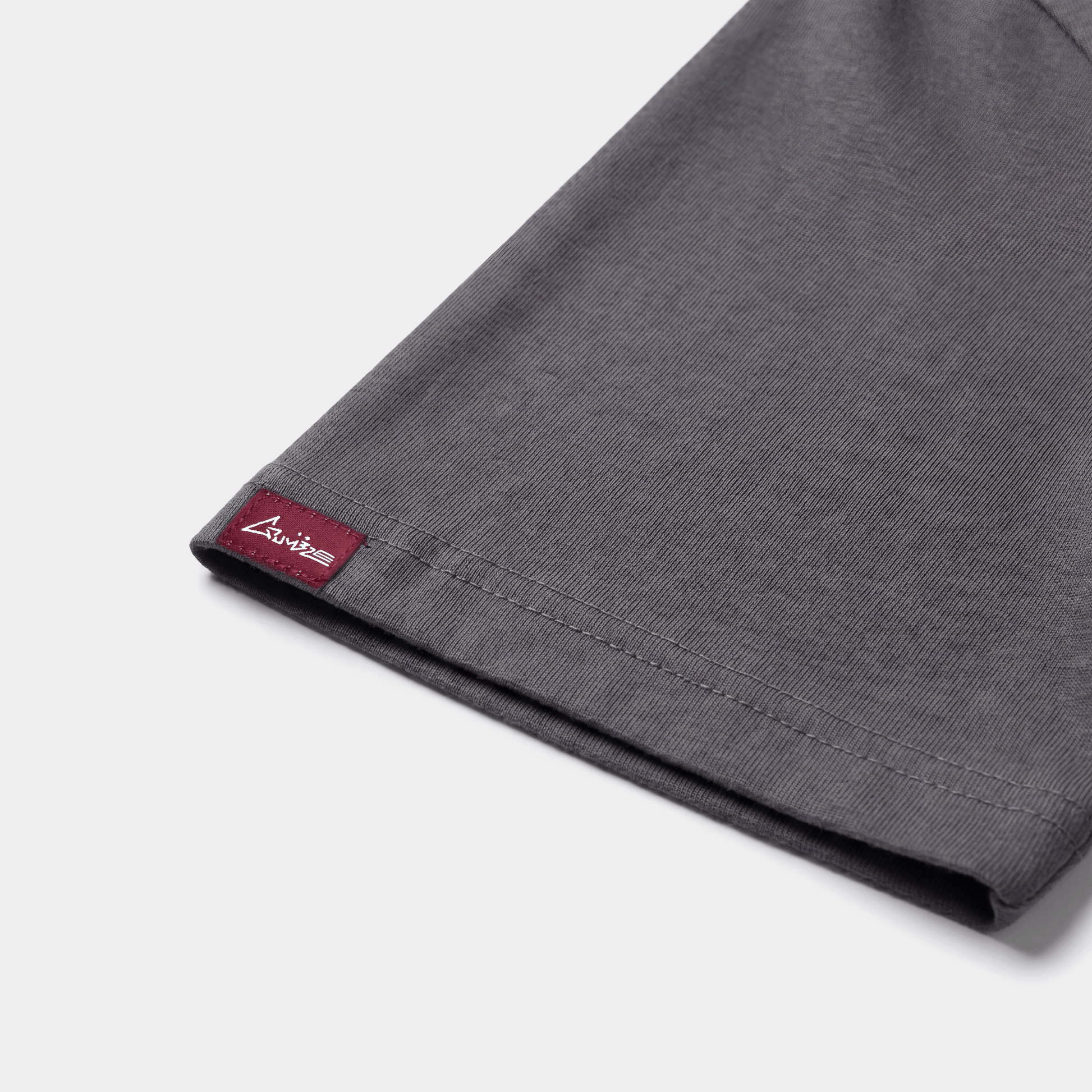 Black AVALIN tee, side sleeve Crumble woven tag visible, profile fit display.
